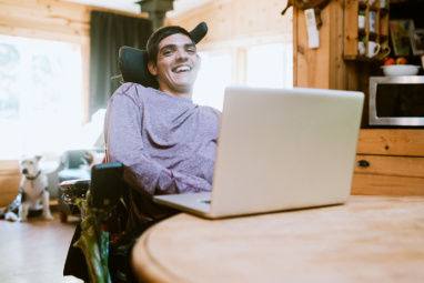 A young man sits working at his laptop