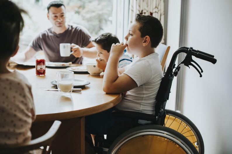 Family at table, including child in wheelchair